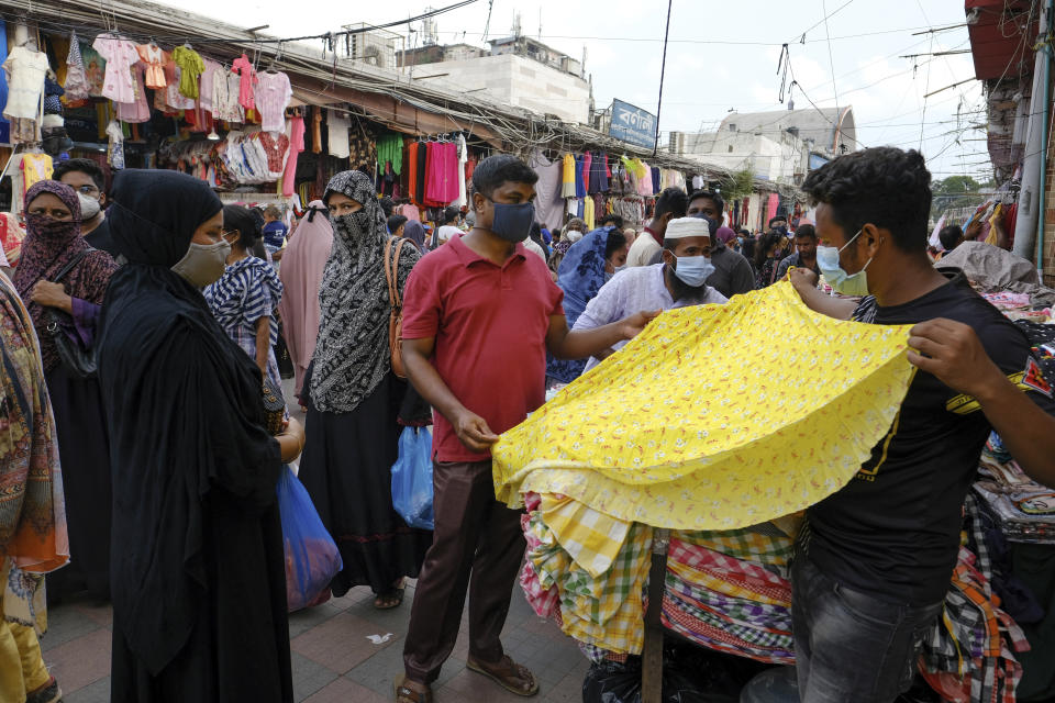 People shop at a market ahead of Eid-al Adha in Dhaka, Bangladesh, Friday, July 16, 2021. Millions of Bangladeshis are shopping and traveling during a controversial eight-day pause in the country’s strict coronavirus lockdown that the government is allowing for the Islamic festival Eid-al Adha. (AP Photo/Mahmud Hossain Opu)