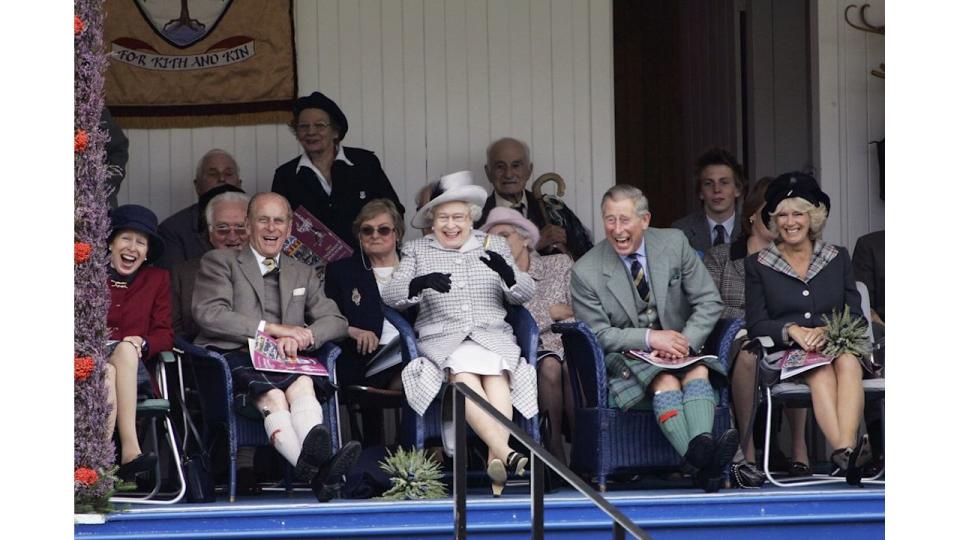 Then-Prince Charles, Prince of Wales and Camilla, Duchess of Cornwall with Queen Elizabeth II and Prince Philip, Duke of Edinburgh laugh at their Balmoral team in the tug of war competition at  the Braemar Games Highland gathering on September 2, 2006, Scotland 