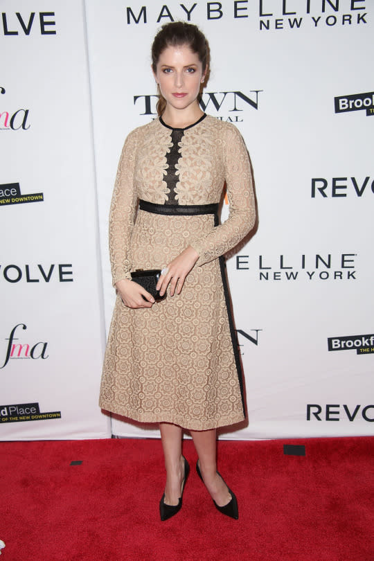 Anna Kendrick in a lace, tea-length dress and black heels.