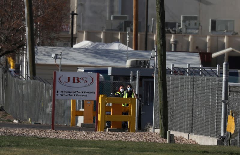 FILE PHOTO: Security wear face mask at the JBS USA meat packing plant in Greeley