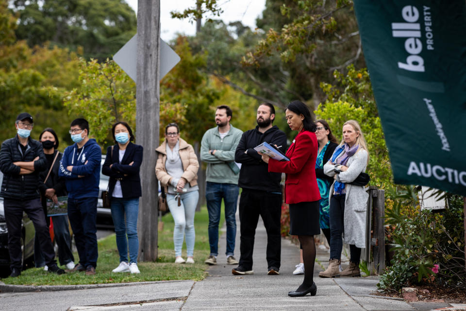 A sales agent with Belle Property Glen Iris is seen as bidders look on during a property auction at Glen Iris in Melbourne, Friday, April 1, 2022. Source: AAP