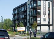 Police investigators walk past a condo building in Longueil