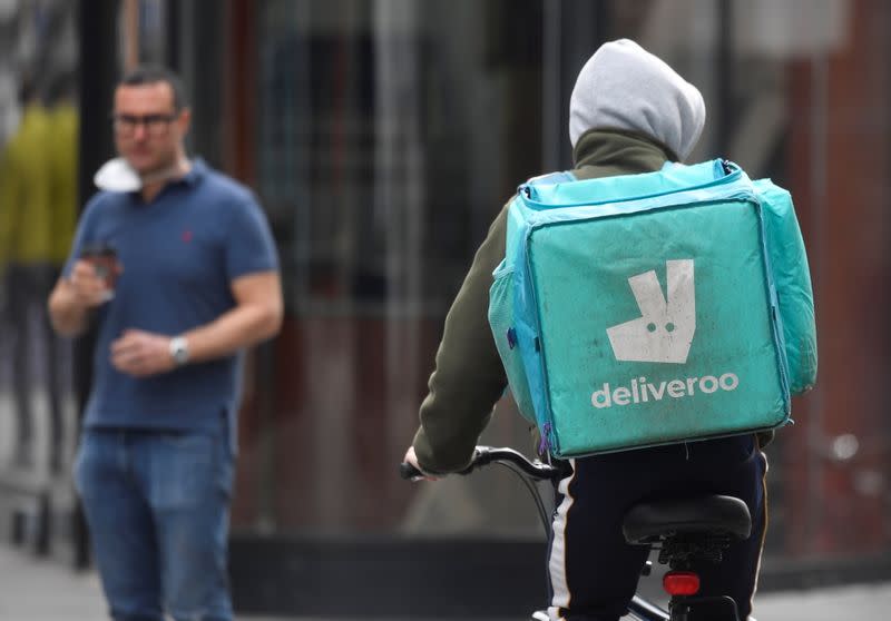 A Deliveroo delivery rider cycles in London