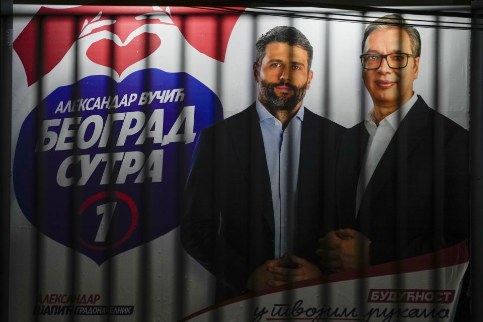 A pre-election billboard showing Serbian President Aleksandar Vucic, right, and Belgrade mayor candidate Aleksandar Sapic, reading: "Belgrade tomorrow" is seen through a fence in Belgrade, Serbia, Wednesday, May 29, 2024, ahead of the municipal vote set for June 2. Voters in Serbia go to the polls this weekend in a municipal election for dozens of cities and towns, including a rerun vote in the capital Belgrade where ruling populists were accused of a fraud at a previous vote in December. The right-wing Serbian Progressive Party of President Aleksandar Vucic is seen as a favorite ahead of the Sunday balloting which could further secure the strongman's already vast hold on power. (AP Photo/Darko Vojinovic)