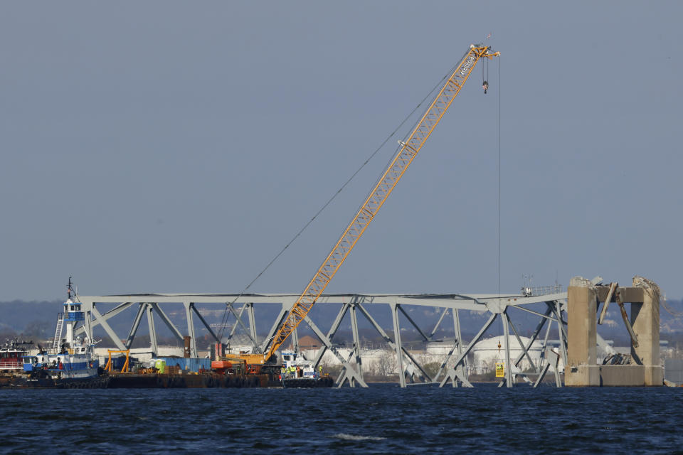 Workers in a crane-held basket mark lines on a damaged section of the Francis Scott Key Bridge, Saturday, March 30, 2024, in Baltimore, Md. (AP Photo/Julia Nikhinson)