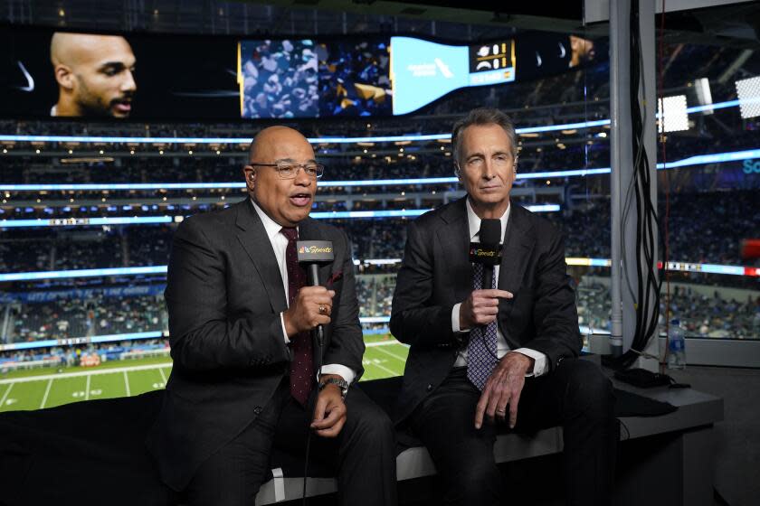 NBC Sports play-by-play announcer Mike Tirico, left, sits next to color commentator Cris Collinsworth