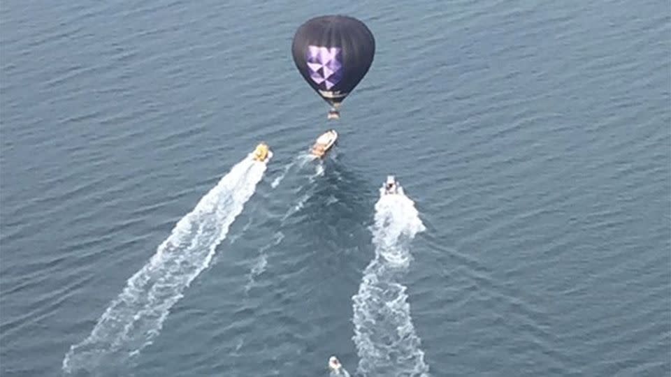 Authorities can be seen going out to rescue 9 passengers on board the hovering balloon. Photo: Twitter/Shayne Whiteley/7 News Heli pilot