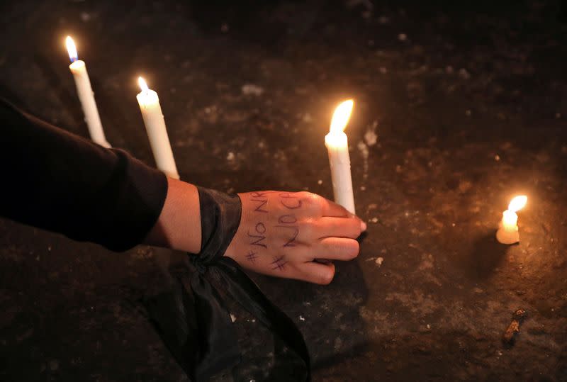 A demonstrator places a candle during a protest against a new citizenship law, in New Delhi