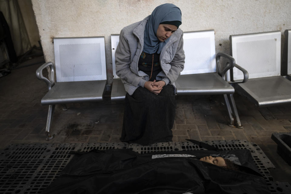 A relative of Palestinian child Alia Abu Taqiya, who was killed in the Israeli bombardment of the Gaza Strip, mourns next to her body outside a morgue in Rafah, southern Gaza, Sunday, Feb. 4, 2024. (AP Photo/Fatima Shbair)