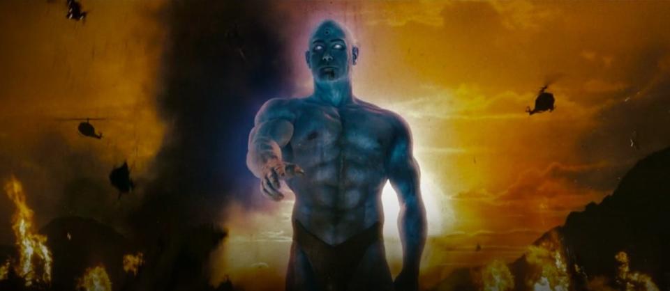 A giant Dr. Manhattan walking through Vietnam with fire and helicopters around him in "Watchmen"