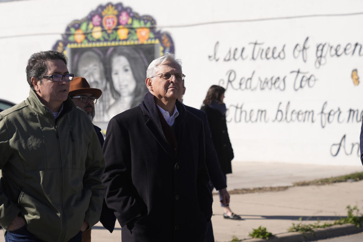 Artist Abel Ortiz, left, gives Attorney General Merrick Garland, right, a tour of murals of shooting victims on Wednesday, Jan. 17, in Uvalde, Texas. 