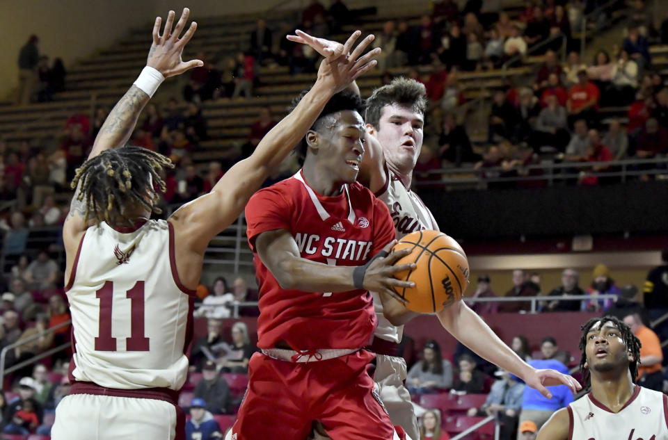 North Carolina State's Jarkel Joiner (1) squeezes past Boston College's Makai Ashton-Langford (11) and Quinten Post (12) to score during the first half of an NCAA college basketball game, Saturday, Feb. 11, 2023, in Boston. (AP Photo/Mark Stockwell)