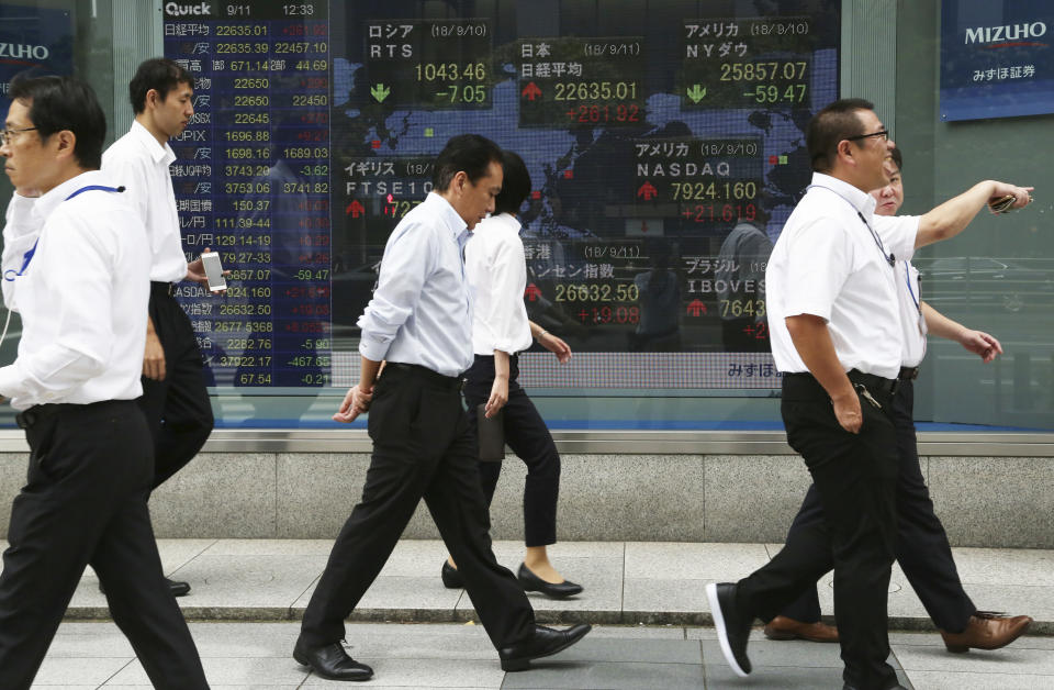 In this Sept. 11, 2018, photo, people walk by an electronic stock board of a securities firm in Tokyo. Shares have fallen in Asia after China rebuffed a plan for talks with the U.S. on resolving their dispute over trade and technology. Shares fell in Hong Kong, India and Australia, while markets in Japan, South Korea and elsewhere were closed Monday, Sept. 24, for national holidays. The slow start to the week followed a mixed close Friday on Wall Street, where an afternoon sell-off erased modest gains for the S&P 500 that had the benchmark index on track to eke out its own record high for much of the day.(AP Photo/Koji Sasahara)