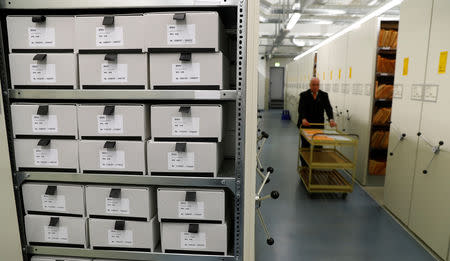 A security staff member pushes a trolley between shelves containing documents of the former East German Ministry for State Security (MfS), known as the Stasi, while he poses during a tour at the central archives office in Berlin, Germany, March 12, 2019. Picture taken March 12, 2019. REUTERS/Fabrizio Bensch