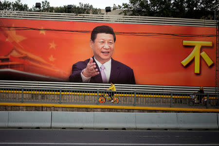 FILE PHOTO: A poster with a portrait of Chinese President Xi Jinping is displayed along a street in Shanghai, China, October 24, 2017. REUTERS/Aly Song/File Photo