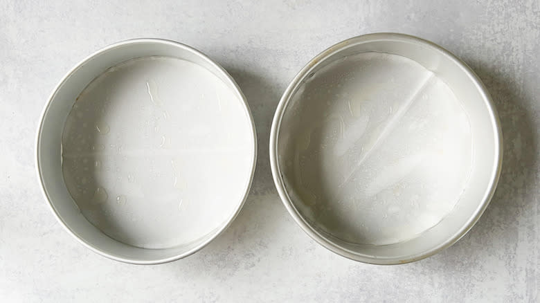 Oiled round cake pans with parchment liners