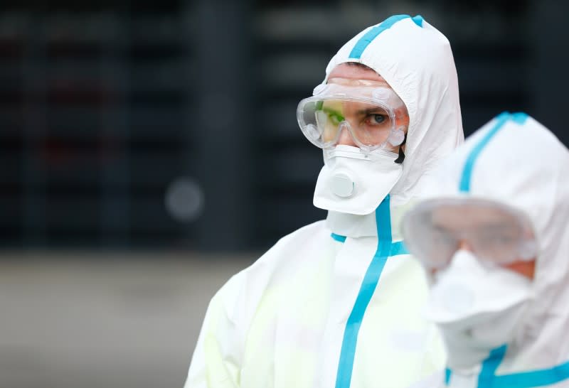 Members of rescue services and firefighters present different versions of protective suits and equipment at a media event in Cologne