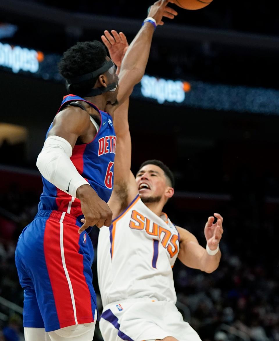 Detroit Pistons guard Hamidou Diallo (6) blocks a shot by Phoenix Suns guard Devin Booker (1) during the second half of an NBA basketball game, Sunday, Jan. 16, 2022, in Detroit. (AP Photo/Carlos Osorio).