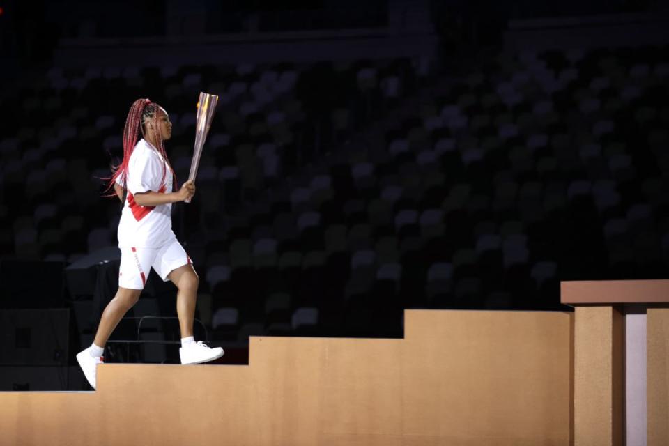 Naomi Osaka carries the Olympic Torch during the opening ceremony in the Olympic Stadium at the 2020 Summer Olympics, Friday, July 23, 2021, in Tokyo, Japan. - Credit: AP