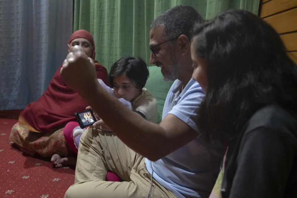 Associated Press photographer Dar Yasin, second from right, celebrates with his family at his home in Srinagar, Indian controlled Kashmir, Tuesday, April 5, 2020, following the announcement that he was one of three AP photographers who won the Pulitzer Prize in Feature Photography for their coverage of the conflict in Kashmir and in Jammu, India. (AP Photo/Rifat Yasin)