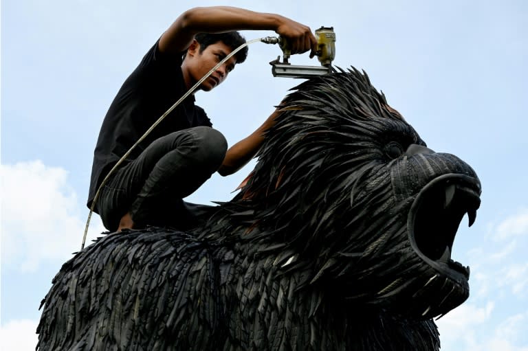 A worker fixes a King Kong statue made with old tyres at artist Mean Tithpheap's house in Cambodia (TANG CHHIN Sothy)