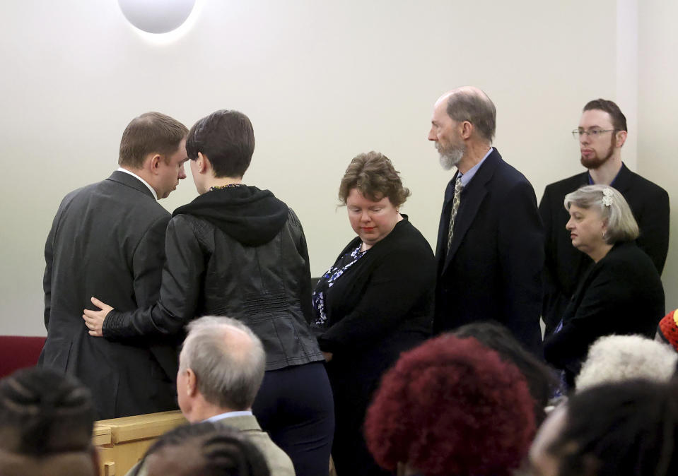 Aaron Dean, left, speaks with his family before the start of the sentencing phase of his trial at Tarrant County's 396th District Court on Friday, Dec. 16, 2022, in Fort Worth, Texas. Dean, a former Fort Worth police officer, was found guilty of manslaughter in the 2019 shooting death of Atatiana Jefferson. (Amanda McCoy/Star-Telegram via AP, Pool)