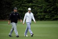 U.S. golfer Patrick Reed (L) and Rory McIlroy of Northern Ireland walk up the 13th fairway during a practice round ahead of the Masters golf tournament at the Augusta National Golf Club in Augusta, Georgia April 8, 2014. REUTERS/Mike Blake (UNITED STATES - Tags: SPORT GOLF)