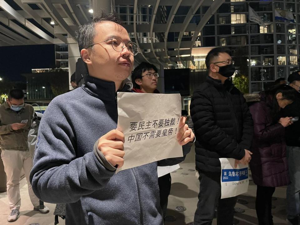 一名華人手舉「要民主不要獨裁，中國不需要皇帝」的標語。（記者李榮／攝影）