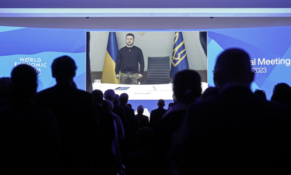 President Volodymyr Zelenskyy of Ukraine is seen on a video screen, holding a minute of silence with participants at the World Economic Forum in Davos, Switzerland, for the victims of a helicopter crash in Ukraine, where Minister of Internal Affairs Denys Monastyrsky died among others on Wednesday, Jan. 18, 2023. The annual meeting of the World Economic Forum is taking place in Davos from Jan. 16 until Jan. 20, 2023. (AP Photo/Markus Schreiber)