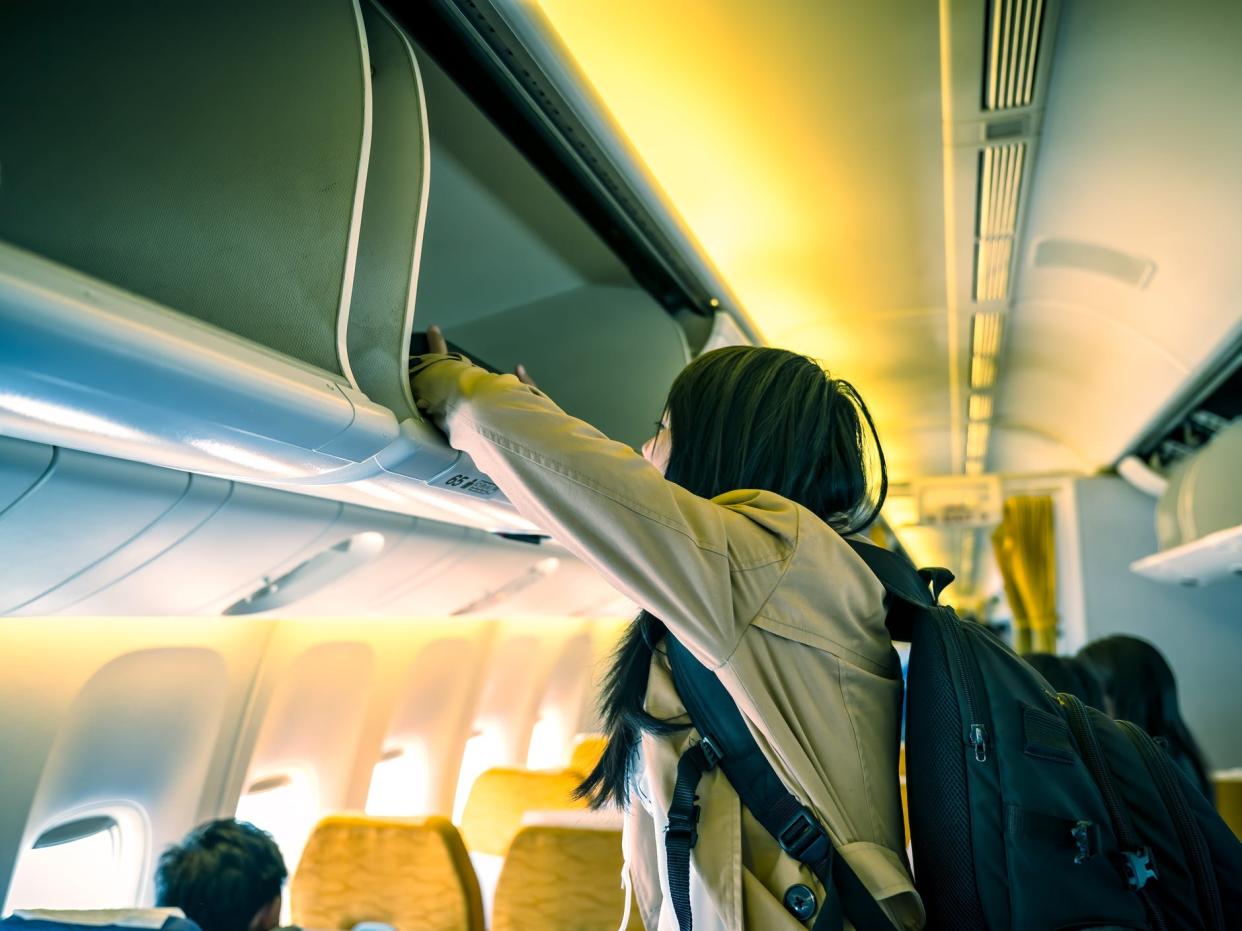 Woman using plane overhead locker