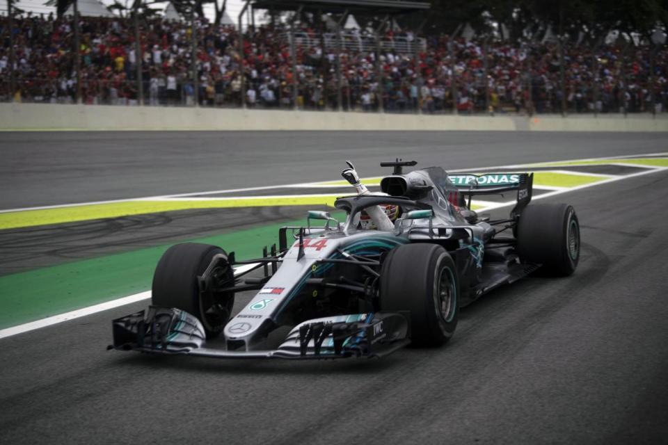 Lewis Hamilton waves from his car after winning the F1 Brazil Grand Prix (Getty Images)