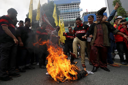 Pro-Palestine protesters burn an effigy of U.S. President Donald Trump as they march towards the U.S. embassy in Kuala Lumpur, Malaysia December 8, 2017. REUTERS/Stringer