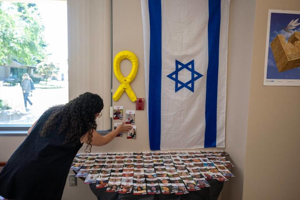 Orit Izilov places photographs of Israelis kidnapped by Hamas during the Oct. 7 attack that sparked the war in Gaza are seen at the new Jewish Life and Resource Center at Sacramento State on Wednesday.