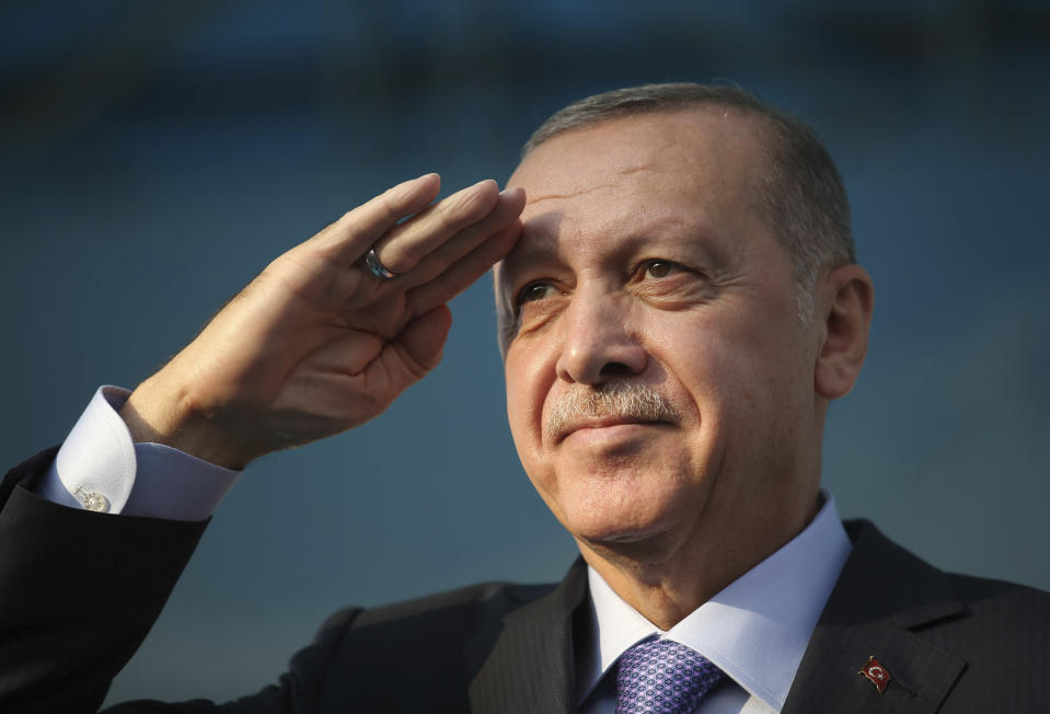 Turkish President Recep Tayyip Erdogan gives a military salute toward his supporters in Kayseri, Turkey, Saturday, Oct. 19, 2019. Turkish Red Crescent says it has delivered humanitarian aid for 2000 people in Syrian town of Ras Al-Ayn and says it also provided aid to Tal Abyad and will continue to do so in areas cleared from Syrian Kurdish fighters.(Presidential Press Service via AP, Pool )