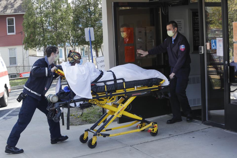 FILE - In this April 22, 2020, file photo medical workers bring a patient to the Northbridge Health Care Center in Bridgeport, Conn. A report from Senate Democrats finds that the Trump administration was slow to comprehend the scale of COVID-19's impact on nursing homes and a disjointed federal response only compounded the devastating toll. (AP Photo/Frank Franklin II)