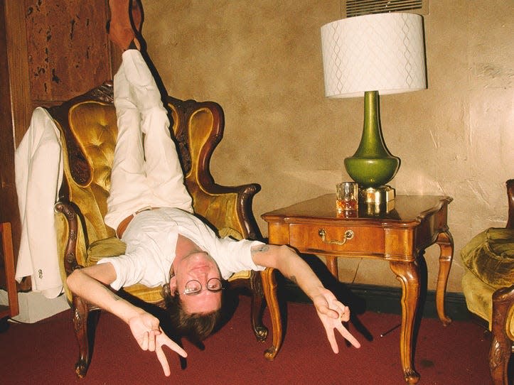 Jackson Greathouse Fall sitting upside down in a chair with sunglasses on.