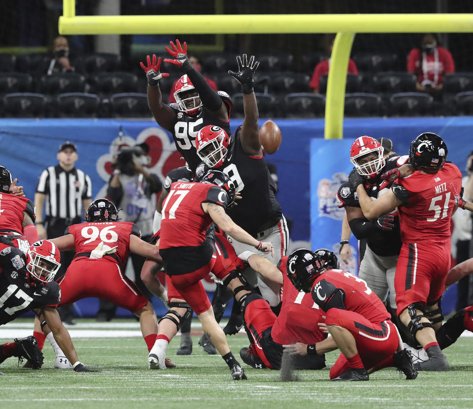 Georgia defensive lineman Jordan Davis, center, blocks the Cincinnati field goal attempt by Cole Smith (17) during the first half in the NCAA college football Peach Bowl game on Friday, Jan. 1, 2021, in Atlanta. (Curtis Compton/Atlanta Journal-Constitution via AP)