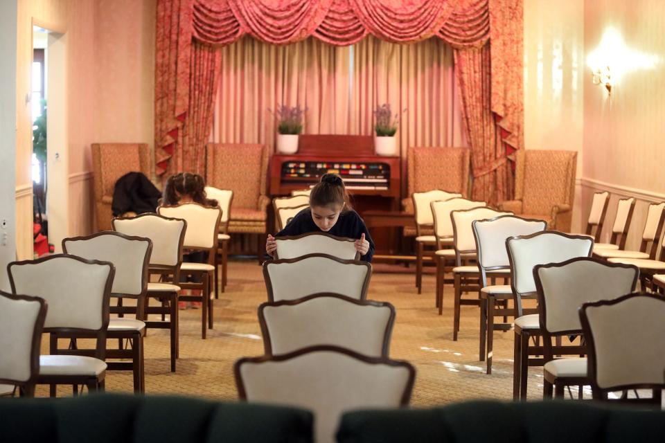 Brooklyn Chiaramonte, 6, and her sister, Phoenix, 3, straighten the chairs at the Nardone Funeral Home, the family business in Peekskill, Feb. 25, 2021. 