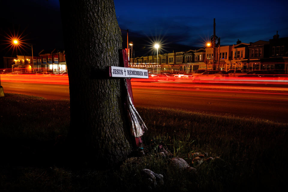 This long exposure photo shows traffic driving on Roosevelt Boulevard by a makeshift memorial for Samara Banks and her three children who were struck and killed by a car in 2013, in Philadelphia, Wednesday, May 25, 2022. (AP Photo/Matt Rourke)