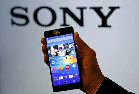 An employee poses with Sony's new Xperia Z4 smartphone after a news conference in Tokyo April 20, 2015. REUTERS/Toru Hanai