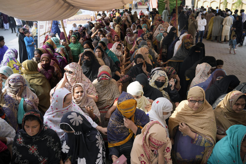 Women wait their turn to get a free sack of wheat flour at a distribution point, in Lahore, Pakistan, Thursday, March 30, 2023. Government is providing free flour to deserving and poor families during the Muslim's holy month of Ramadan due to high inflation in the country. (AP Photo/K.M. Chaudary)