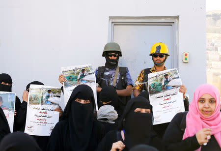 Police troopers secure a door of the United Nations offices as women demonstrate to demand the reopening of Sanaa airport in Sanaa, Yemen December 10, 2018. The posters read: "Open Sanaa airport to limit the suffering and deaths!". REUTERS/Khaled Abdullah