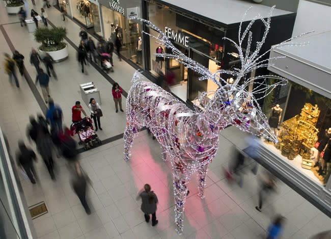Shoppers pass by a lit reindeer at a downtown department store in Toronto on December 23, 2012. THE CANADIAN PRESS/Frank Gunn
