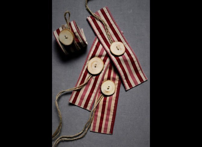 Create a rustic vibe by sewing a wooden button onto a strip of fabric and adding a twine cord. Or, you can purchase these ones <a href="http://www.bhldn.com/shop%5Fsale%5Fdecor/button%2Dnose%2Dnapkin%2Drings%2Dstripes" target="_hplink">here</a>.       Photo by BHLDN  