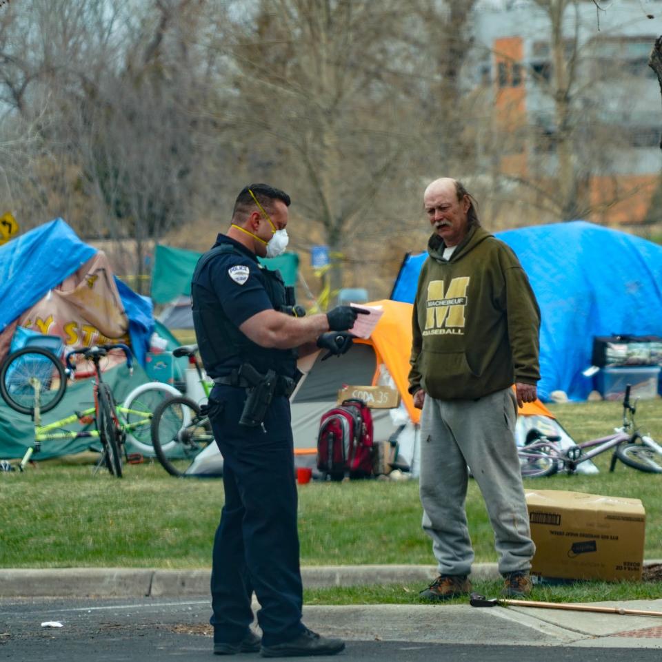 A police officer explains why he's giving a ticket to a man who was camping outside a Fort Collins, Colorado, emergency shelter set up to aid people experiencing homelessness during the coronavirus outbreak. Police officers confiscated a large knife from the man, who said he needed it for self-protection with staying in the encampment set up on the playing field. Officers ordered the man to pack up his belongings and leave the encampment.