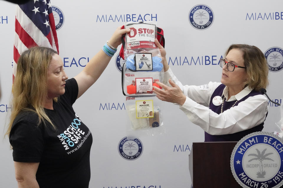FILE - Lori Alhadeff, left, and Dr. Patricia Byers, a surgical critical care and trauma surgeon, point out the contents of a Stop the Bleed kit during a news conference, Monday, Feb. 28, 2022, in Miami Beach, Fla. Alhadeff, who lost her 14-year-old daughter, Alyssa during the Parkland, Fla., school shooting, helped provide the kits that will be placed in Miami Beach schools through her Make Our Schools Safe organization. (AP Photo/Wilfredo Lee, File)