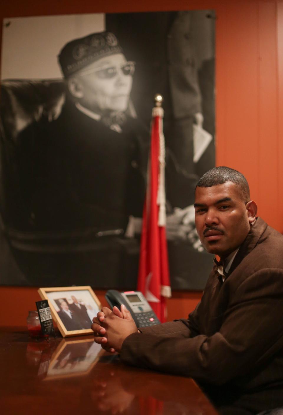 Student minister Troy Muhammad sits in front of a large photo of Elijah Muhammad in his office at Muhammad's Mosque No. 1 in Detroit on Monday, Feb. 18, 2014. Muhammad is the host minister for the upcoming national convention of the Nation of Islam that will be held in Detroit called Saviours' Day.