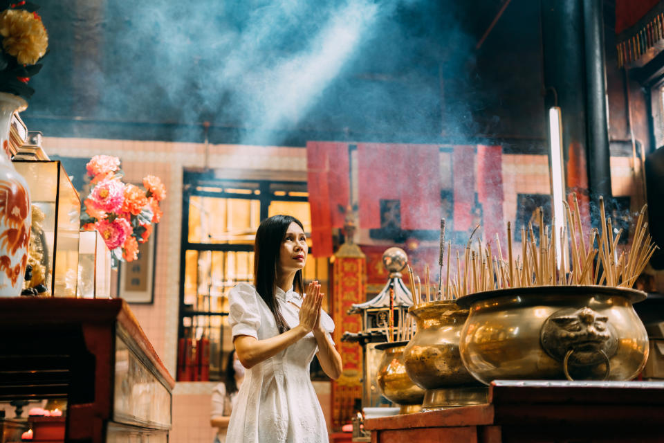 asian women prays at chinese Temple, putting palms together praying sincerely and devoutly