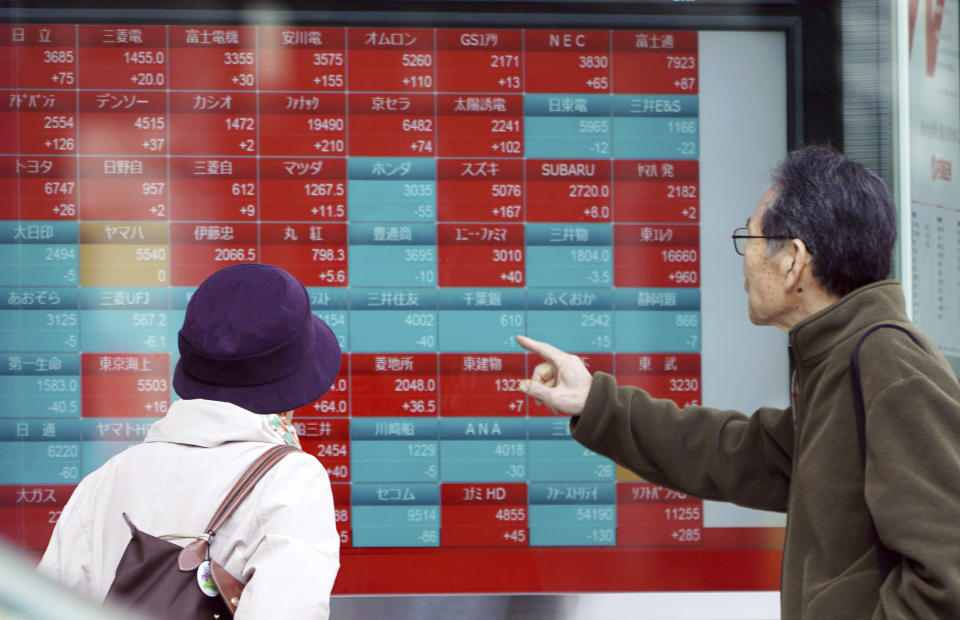 A man and a woman look at an electronic stock board showing Japan's Nikkei 225 index at a securities firm in Tokyo Friday, March 22, 2019. Asian markets were mostly lower on Friday as investors mulled over the possibility of a trade deal between the U.S. and China in the near future, ahead of the continuation of talks in Beijing next week. (AP Photo/Eugene Hoshiko)