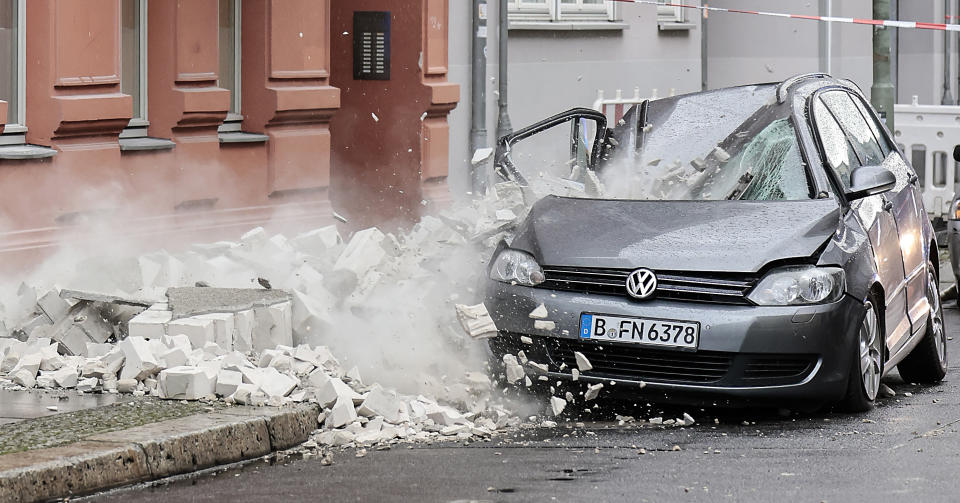 A part of a damaged wall crashes onto the pavement during a storm in Berlin, Germany, Thursday, Feb. 17, 2022. Meteorologists warned Thursday that northern Europe could be battered by a series of storms over the coming days after strong winds swept across the region overnight. (AP Photo/Hannibal Hanschke)